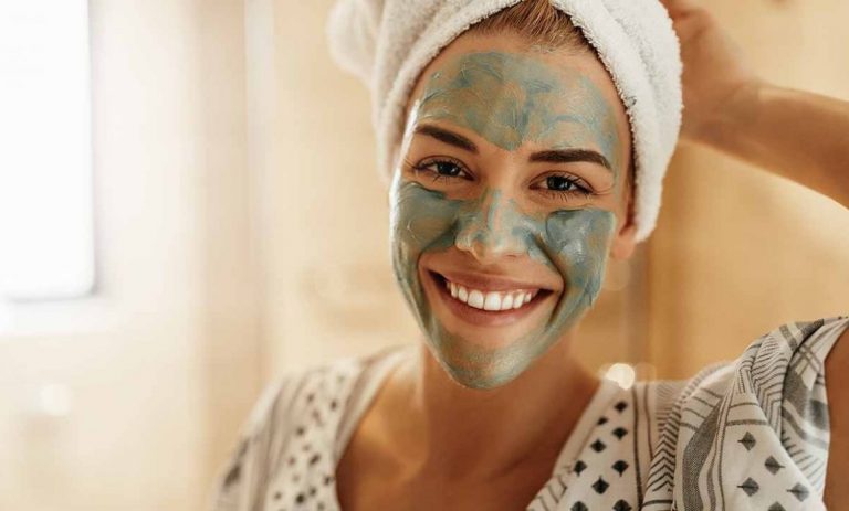 a woman with a towel on her head and a green facial mask