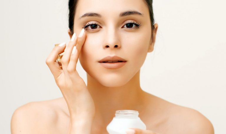 a woman applying cream on her face