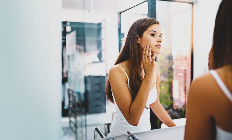 a woman looking at her face
