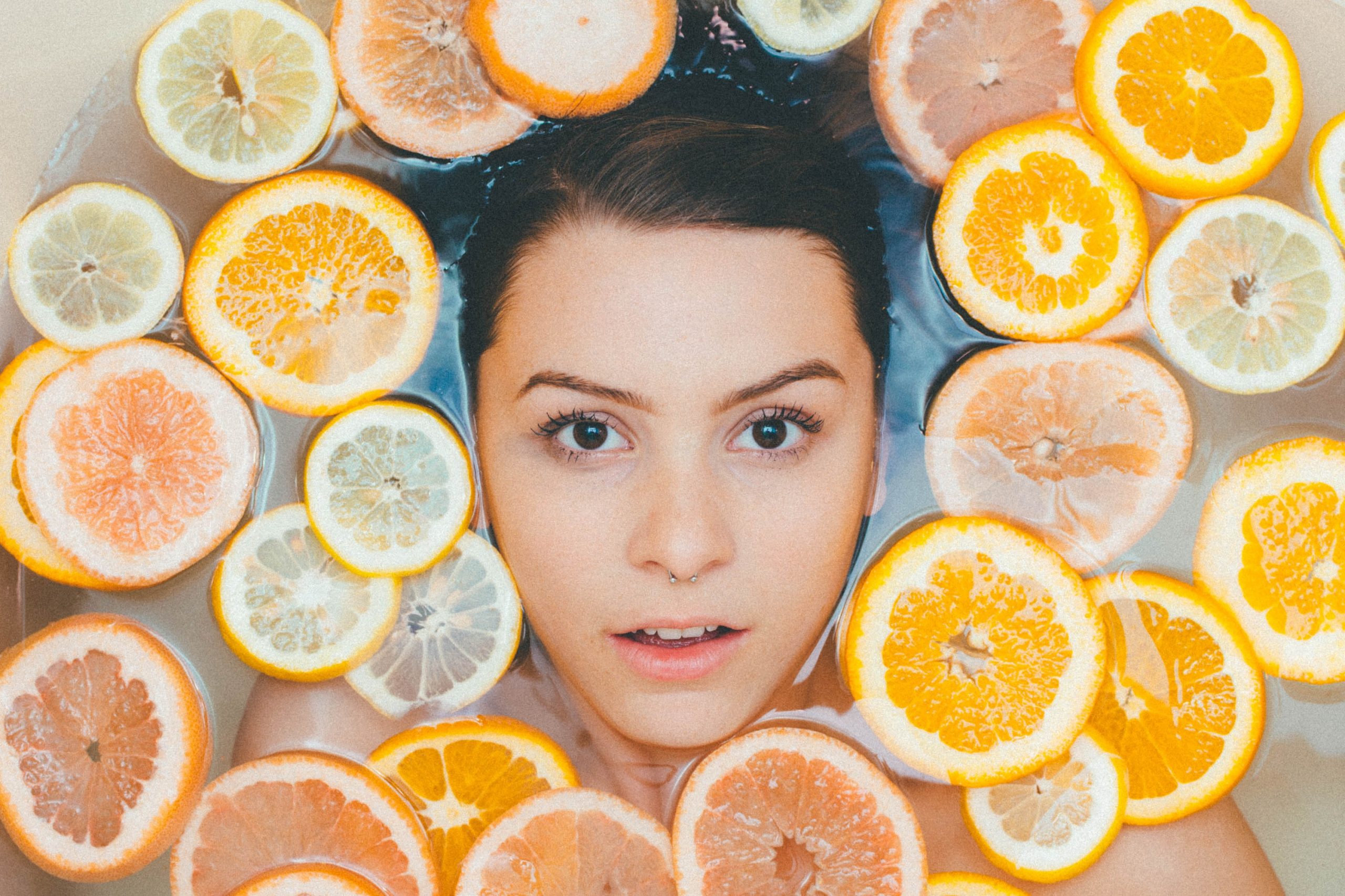 a woman in a bath with slices of oranges