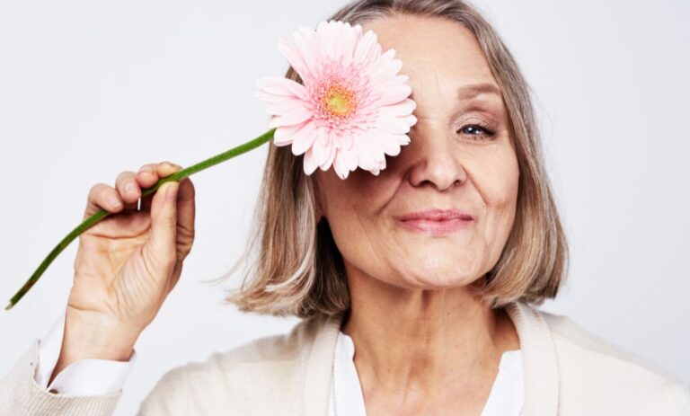 Mature woman with ageing skin holding a sunflower